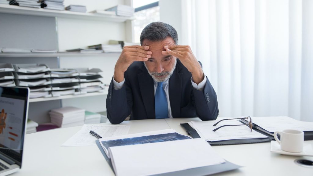 Business man stressed looking at paperwork