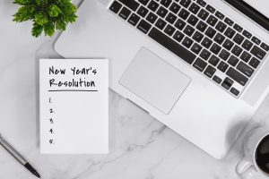 New Year's Resolution List on Notebook With Laptop
