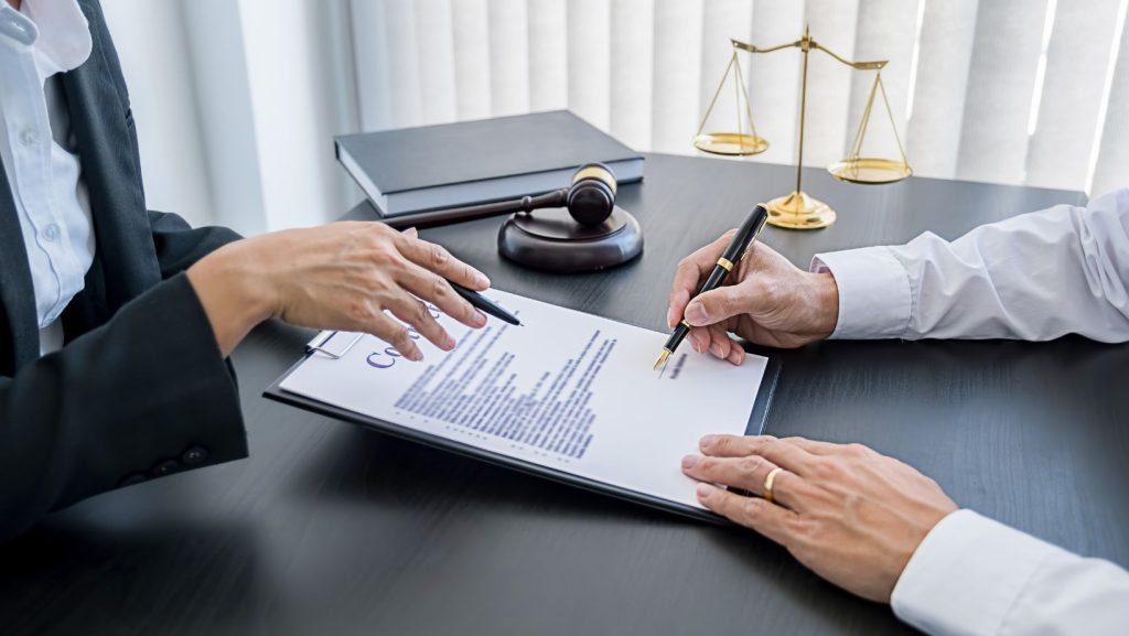 Close up of hands signing a contract on a clipboard.
