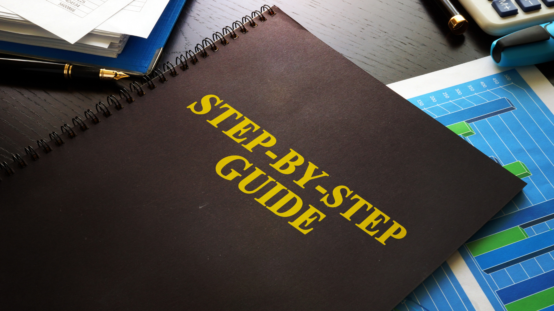 A spiral bound black book with the title 'Step by Step Guide' printed on it